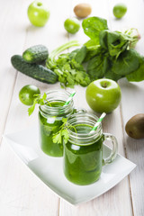 Bebida green smoothie o batido verde energético con frutas hojas de espinacas y verduras para una dieta sana en mason jar con pajita en espiral