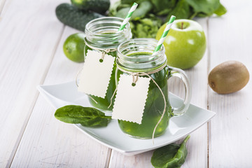Bebida green smoothie o batido verde energético con frutas hojas de espinacas y verduras para una dieta sana en mason jar con pajita en espiral