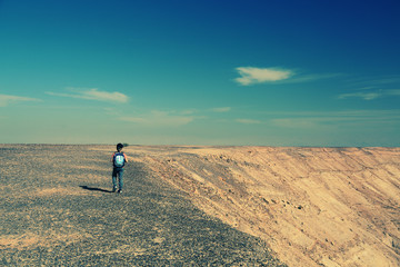 Cute 8 years old boy hiking in the desert