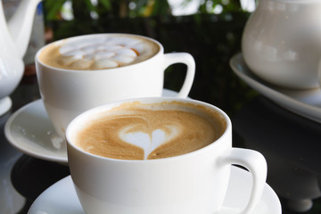 Close up cup of Coffee, latte on the black glass table