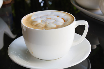 Close up cup of Coffee, latte on the black glass table
