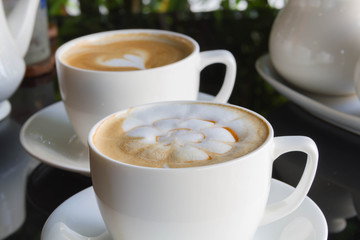 Close up cup of Coffee, latte on the black glass table