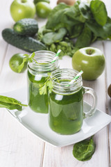 Bebida green smoothie o batido verde energético con frutas hojas de espinacas y verduras para una dieta sana en mason jar con pajita en espiral