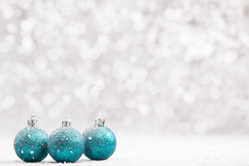 Christmas ball in the snow on blurred light background. A holiday card. Traditional Christmas...