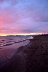 Sea waves during a colorful sunset over a beautiful and romantic beach