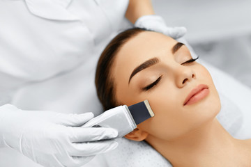 Skin Care. Close-up Of Beautiful Woman Receiving Ultrasound Cavitation Facial Peeling. Ultrasonic Skin Cleansing Procedure. Beauty Treatment. Cosmetology. Beauty Spa Salon. - obrazy, fototapety, plakaty