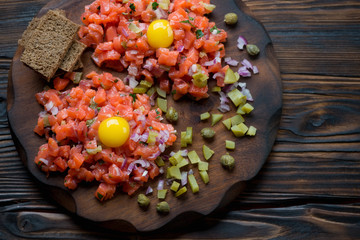 Close-up of fresh salmon tartar with egg yolk, studio shot