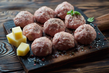 Uncooked meatballs with seasonings, selective focus, studio shot
