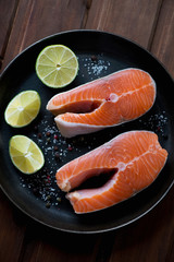 Frying pan with uncooked trout steaks, view from above