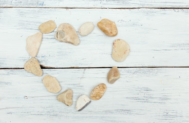 A heart shaped pebble stones on a old wood planks