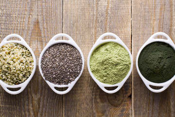 Superfood raw seeds and powder. Body building powders and health food on wooden background....