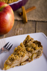 Pie with crumble on plank background. Apple crumble. Apple pie with crumble on wooden background. 