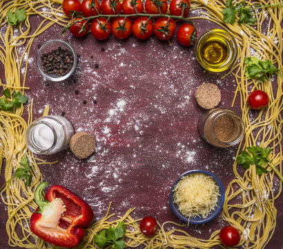 raw pasta, lined frame around ingredients, grated cheese, peppers, pepper, salt on wooden rustic background top view