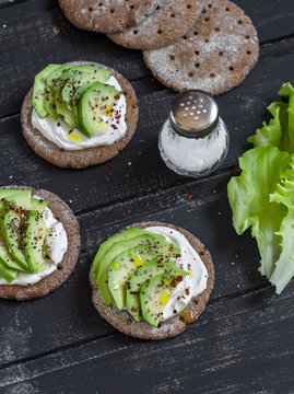 Healthy avocado sandwiches,  on a dark wooden surface. Healthy breakfast or snack