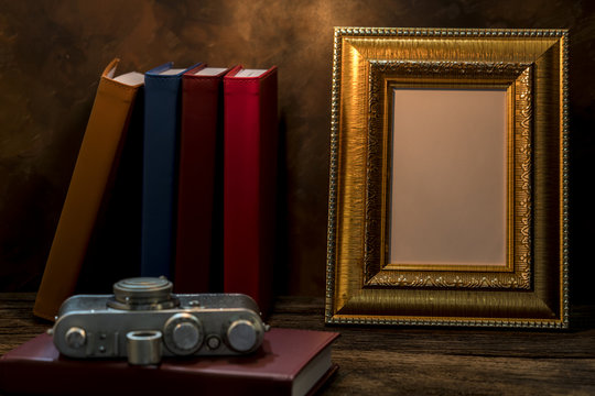 Still life of picture frame on table with vintage camera