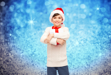 smiling happy boy in santa hat with gift box