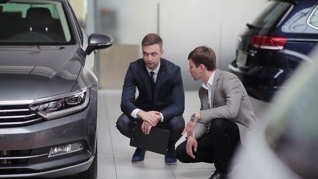 Two young guys discussing car specification