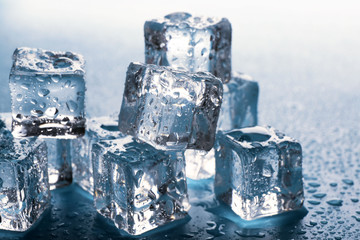 Melting ice cubes with drops around, close up