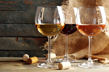 Composition of wine glasses and corks on wooden background