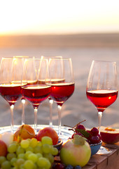 Glasses of the red wine on the sunset beach