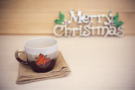 Christmas cup with Christmas decorated on wooden table.