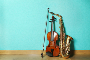 Violin and saxophone on the floor against blue background