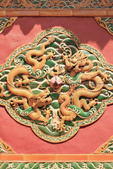 Artwork with dragons on a wall of an ancient Buddhist temple, Beijing, China