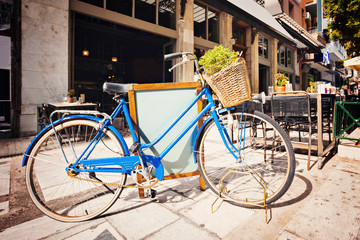 Naklejka na ściany i meble Old bicycle with a basket on a street of Athens, Greece