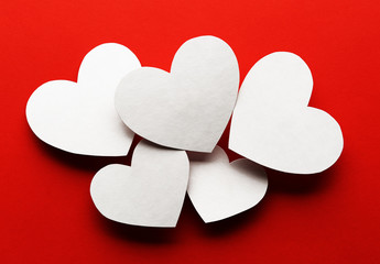 Obraz premium White paper hearts on red background