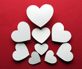 White paper hearts on dark pink background