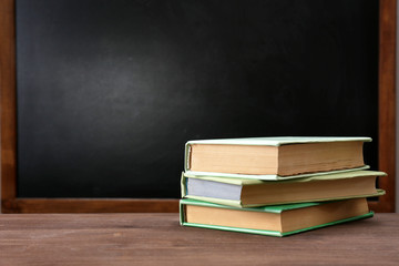 School equipment on desk on blackboard background
