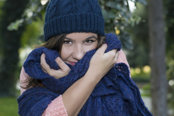 brunette girl in a knitted hat in a Park in autumn