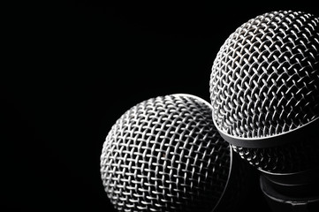Two microphones on a black background.