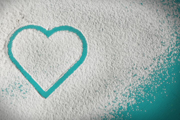 Heart of flour on color wooden background