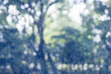 rain drop on window glass with blur tree background, vintage col
