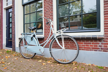 Classic Dutch bicycle parked against a brick house in autumn, Gouda, The Netherlands