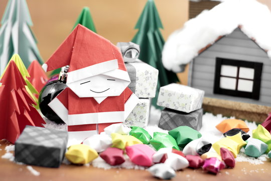 Santa claus and gift box with small star paper on the snow field