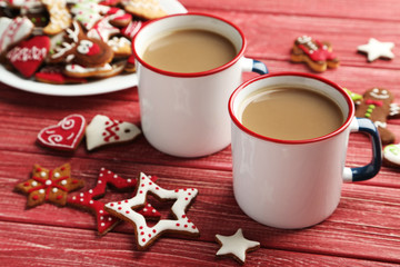 Christmas cookies with cup of hot coffee on a red wooden table