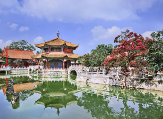 Naklejka premium Pavilion mirrored in green pond, Yuantong Temple, Kunming, Yunnan Province, China.