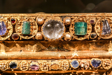 Antique gold jewelry with green and transparent stones.