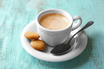 Cup of coffee on color wooden background