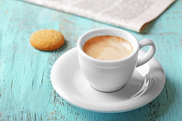 Cup of coffee on color wooden background
