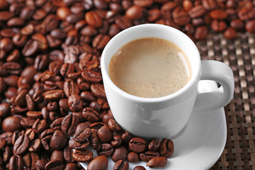 Cup of coffee and coffee grains on dark background