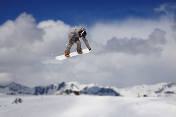 Flying snowboarder on mountains. Extreme sport.