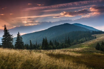 Plakat Colorful sunset in the mountains landscape. Dramatic overcast sky.