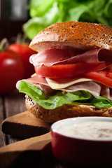 Delicious sandwich with prosciutto ham, cheese and vegetables