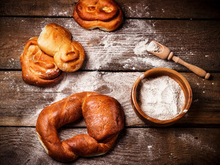 Freshly baked bread rolls on old wooden table.