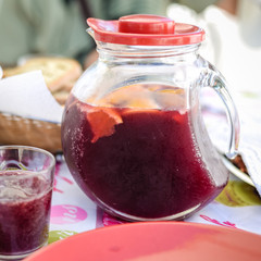 Tasty homemade fruit compote with lemon slices in glass pitcher 