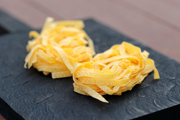 Egg tagliatelle on wooden plank