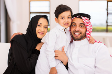 arabian couple with their son sitting on couch